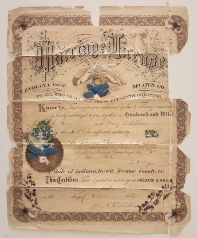 An 1883 Indiana marriage licence creased into panels, its engraved border and ink worn along the folds